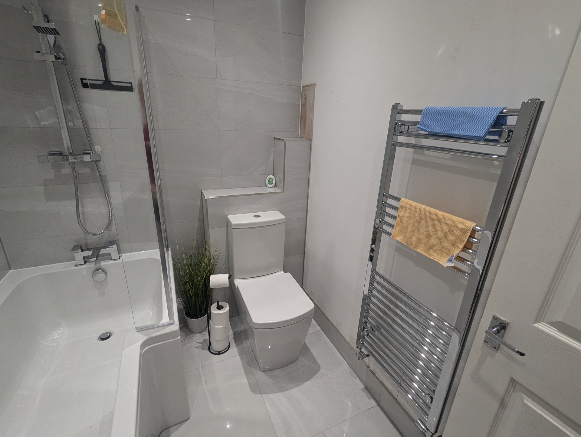 Grey tiled bathroom with chrome fixtures